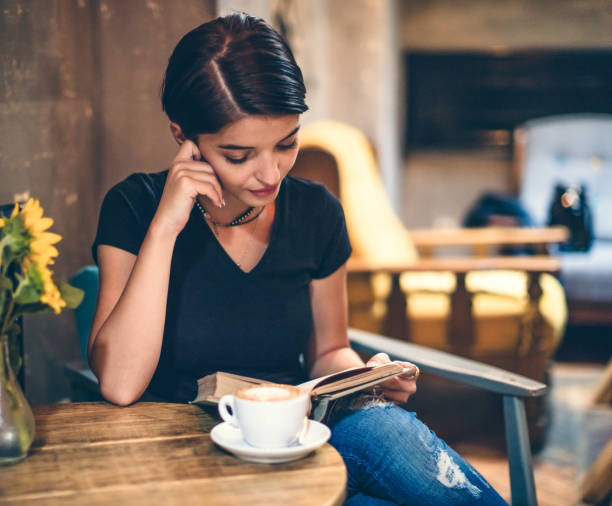istock Girl Drinking Coffee and Reading Book in Cafe 836358668