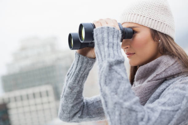 istock Gorgeous woman with winter clothes on using binoculars 836364374