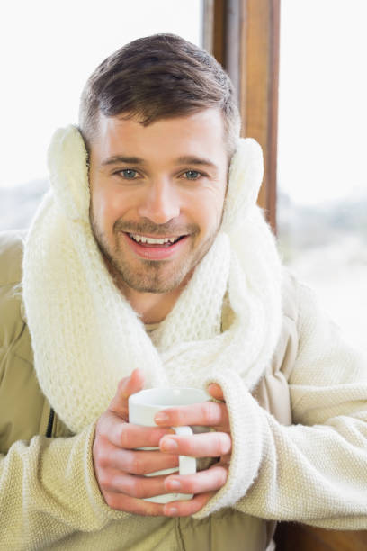 istock Smiling man wearing earmuff with coffee cup 836371834