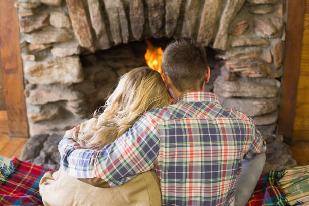 istock Romantic couple sitting in front of lit fireplace 836372092