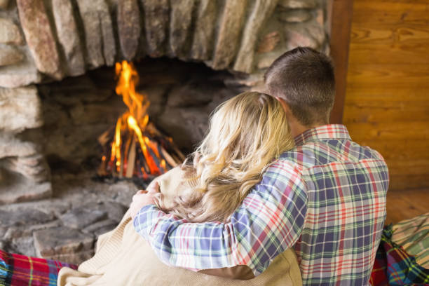 istock Romantic couple sitting in front of lit fireplace 836372234