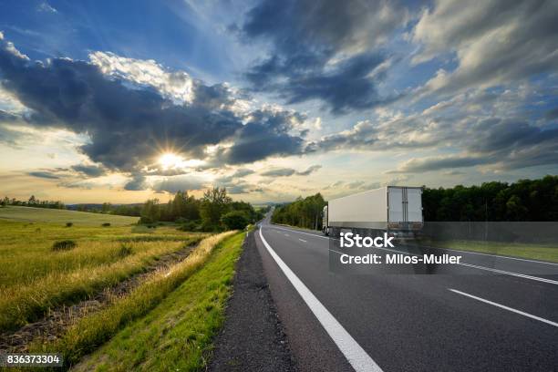 Truck On The Road In Rural Landscape At Sunset Stock Photo - Download Image Now - Truck, Semi-Truck, Highway
