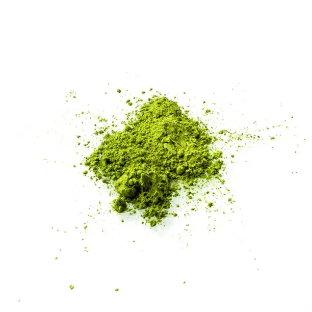 Matcha green tea powder on white background top view. Matcha is made of finely ground green tea powder. It's very common in japanese culture. Matcha is healthy due to it's high antioxydant count.