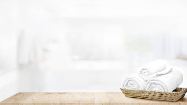 istock Towels in basket on top wood table with copy space on blurred bathroom background. 