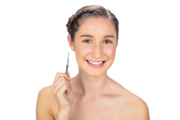 Smiling gorgeous model holding tweezers Smiling gorgeous model on white background holding tweezers late teens isolated on white one person cute stock pictures, royalty-free photos & images