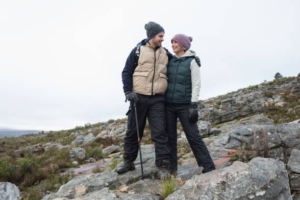 istock Couple standing on rocky landscape against the sky 836393714
