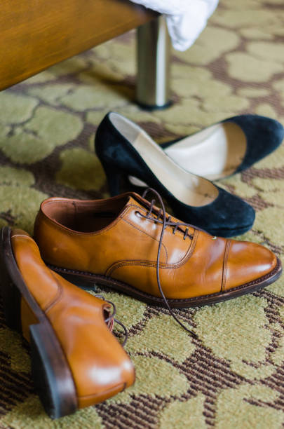 istock Men and women's shoes sitting next to a bed 836394822