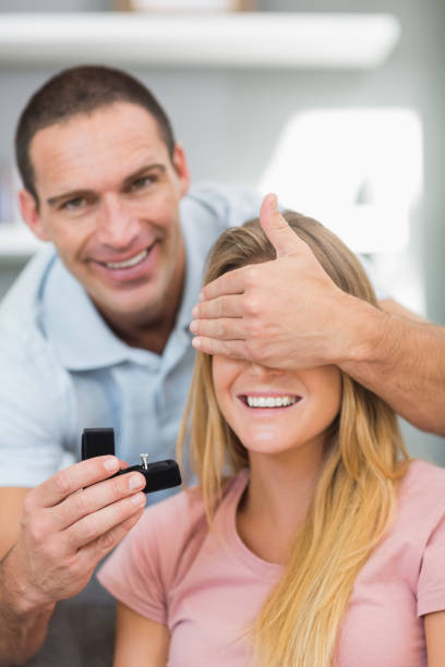 istock Man about to propose to his unsuspecting girlfriend on the sofa 836394986
