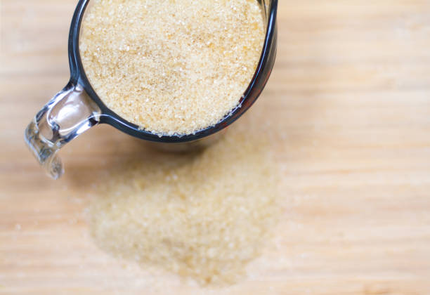 istock Brown Organic Cane Sugar in Measuring Cup, Some Spillover 836395370