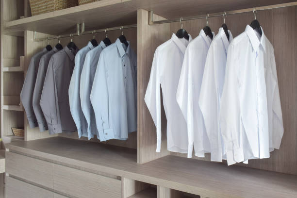 Classic color shirts hanging in warm wooden wardrobe stock photo