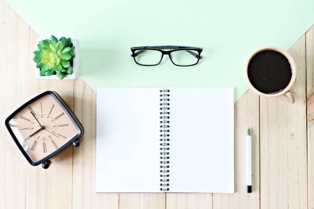 istock Top view image of open notebook paper with blank pages, accessories and coffee cup on wooden background, ready for adding or mock up 836398426