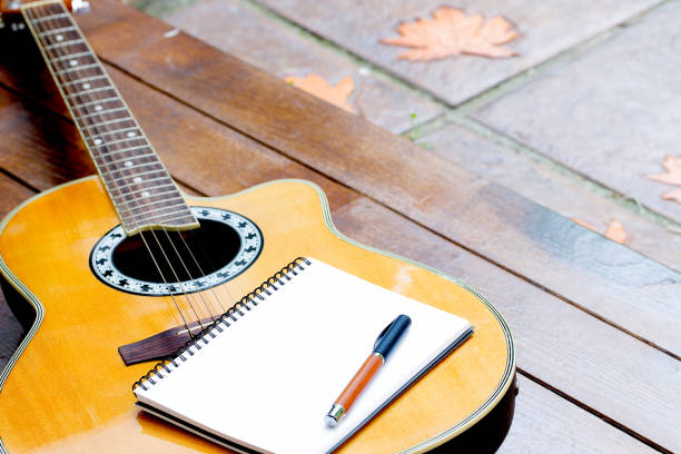 guitarra acústica con cuaderno y lápiz sobre fondo de madera - wood texture audio fotografías e imágenes de stock