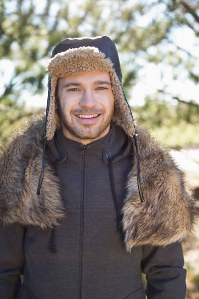 istock Smiling man in warm clothing standing in forest 836401882