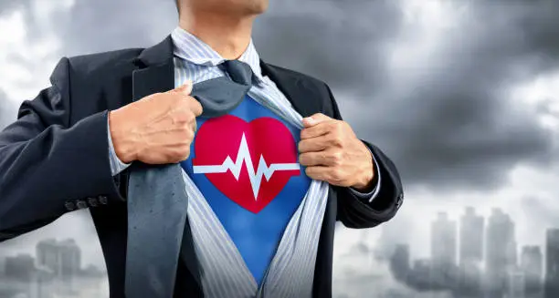 businessman in superhero costume with heartbeat