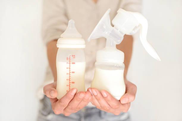 istock Breast pump and bottle with milk in woman's hand 836418338
