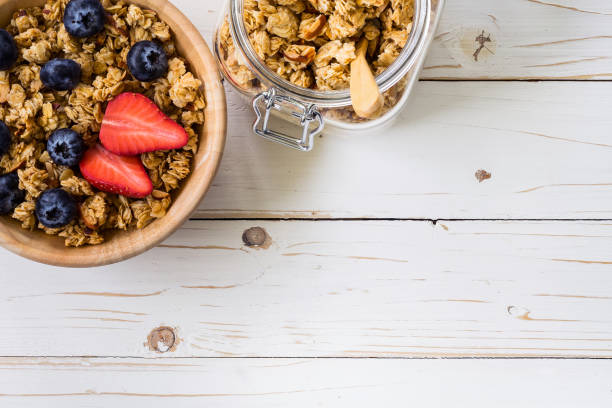 istock Homemade granola and fresh berries on wood table with space. 836421956
