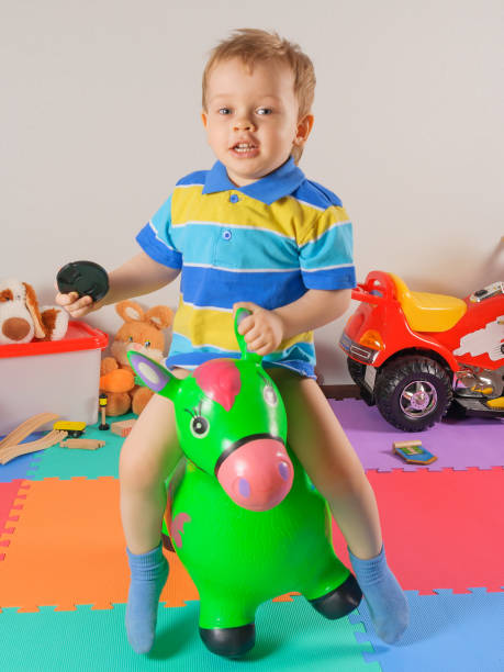 istock Llittle happy boy jumping toy horse 836423398