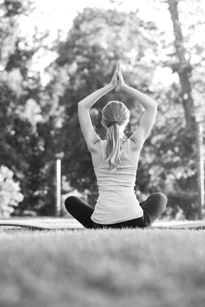 istock Young woman practicing yoga outdoors at the park 836430372