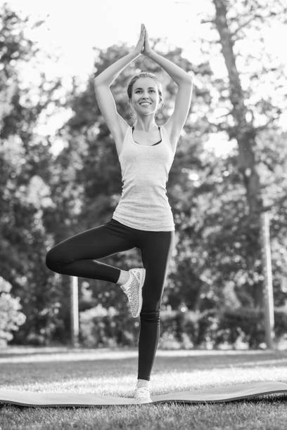 istock Young woman practicing yoga outdoors at the park 836430458
