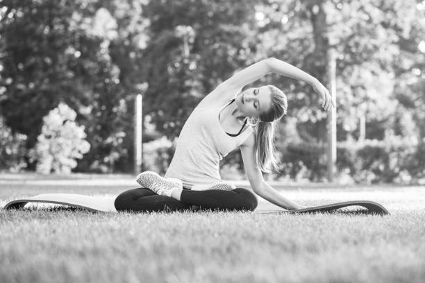 istock Young woman practicing yoga outdoors at the park 836430546