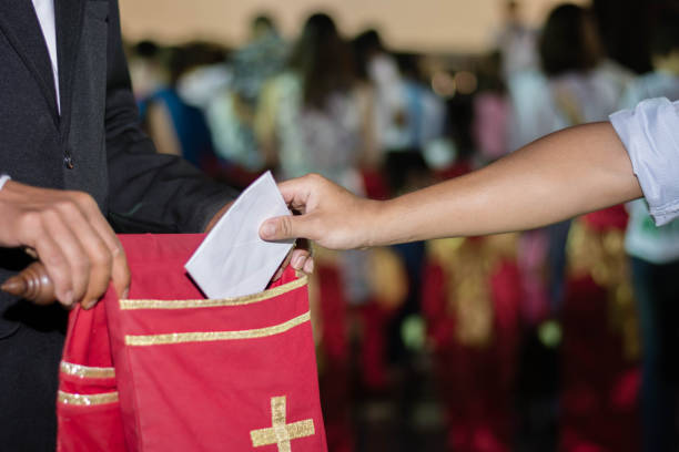 ludzie wkładający dziesięcinę do velvet oferując torbę w kościele - tithe zdjęcia i obrazy z banku zdjęć