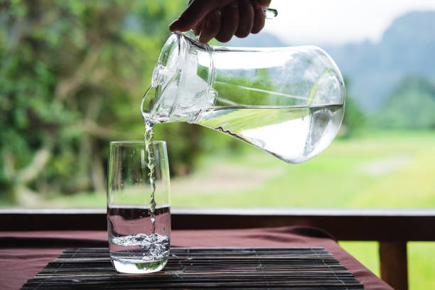 istock Hand pouring water in glass 836433518