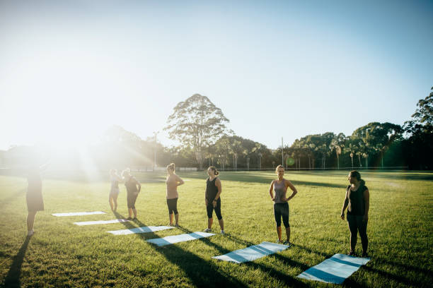 pronto, impostato, bagliore - yoga exercising outdoors group of people foto e immagini stock