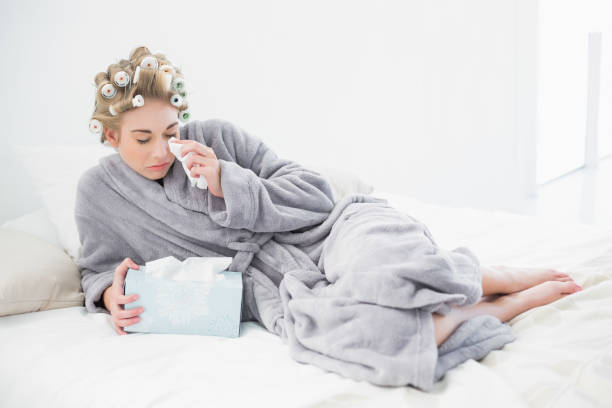 istock Sad blonde woman in hair curlers crying and using tissues 836441204