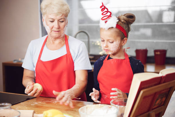 istock Grandmother and granddaughter making dough in kitchen 836442106