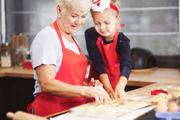 istock Cute girl with her grandma making dough 836445198