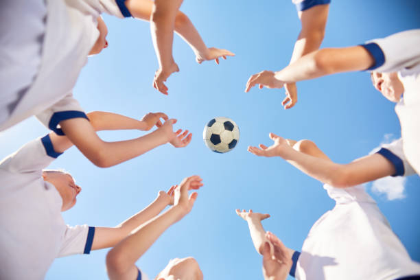 少年サッカー チームを投げてボール - catching football human hand ball ストックフォトと画像