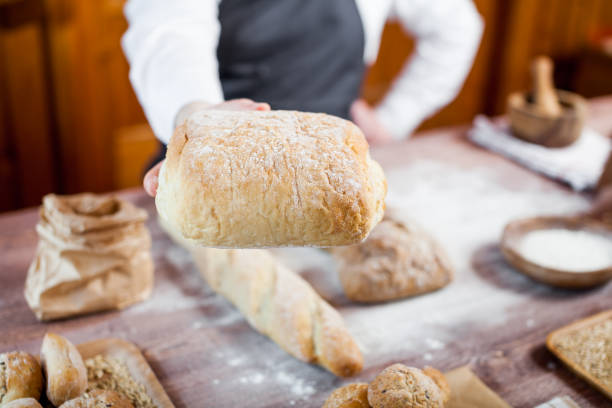 istock Baker man holding a beautiful fresh bread 836461358