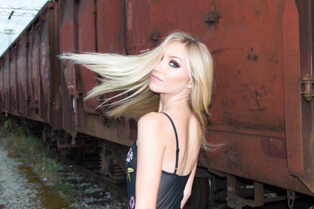 istock Beautiful blonde girl walking on rail tracks 836468332