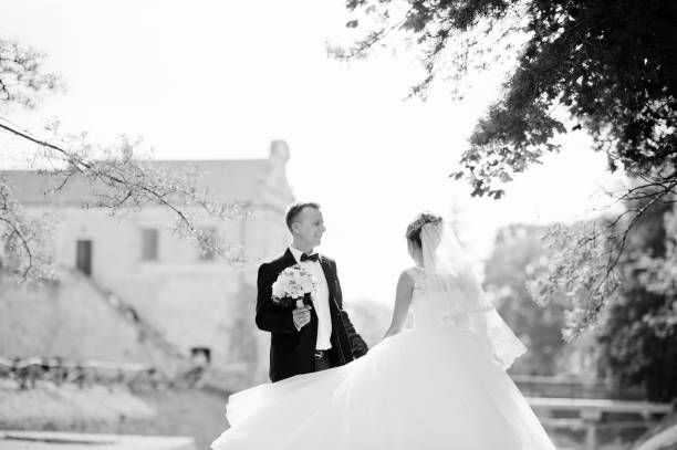 istock Fantastic wedding couple posing on the hill with a marvellous view at an ancient castle. Black and white photo. 836469330