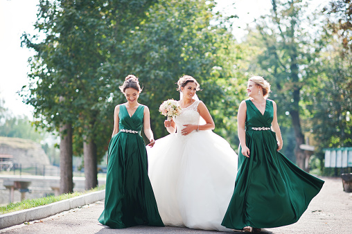 Fabulous bride walking, posing and having fun with her bridesmaids in the downtown on a wedding day.