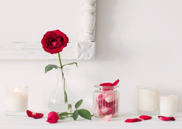 istock roses in a vase and candles on white background 836473814