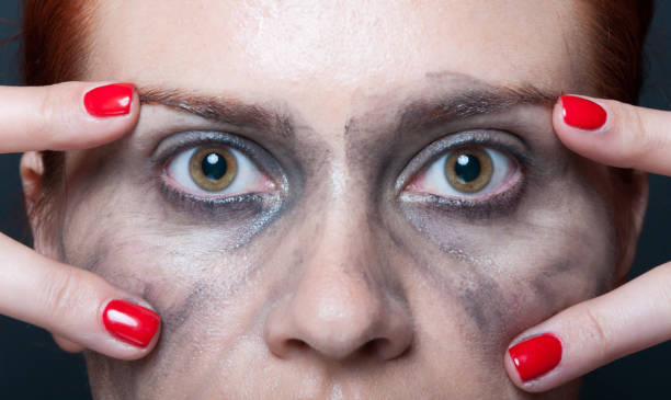 Young woman showing her eyes in closeup Young woman showing her eyes and face with dirty make up in closeup woman mascara smudged stock pictures, royalty-free photos & images
