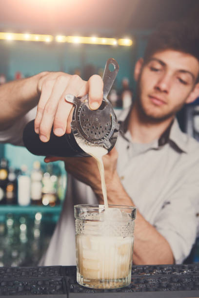 istock Young bartender pouring cocktail drink into glass 836478726