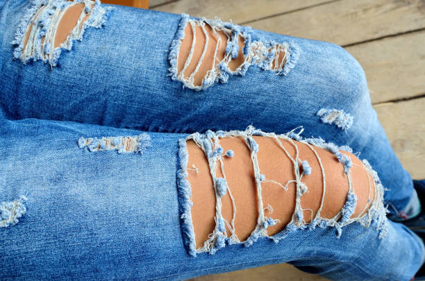 istock Ragged blue jeans on slender women's legs 836484912