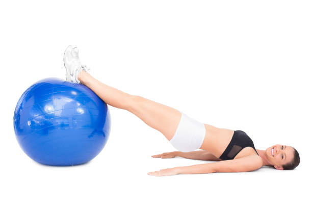 istock Smiling sporty woman working out with blue exercise ball 836490998