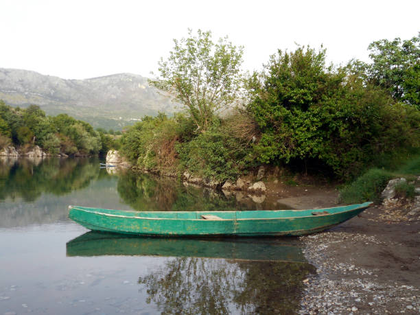 Landscape with an old wooden boat that is reflected on the calm surface of the river Landscape with an old wooden boat that is reflected on the calm surface of the river bush land natural phenomenon environmental conservation stone stock pictures, royalty-free photos & images