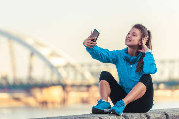 istock Young woman jogger using smart phone by the river 836502748