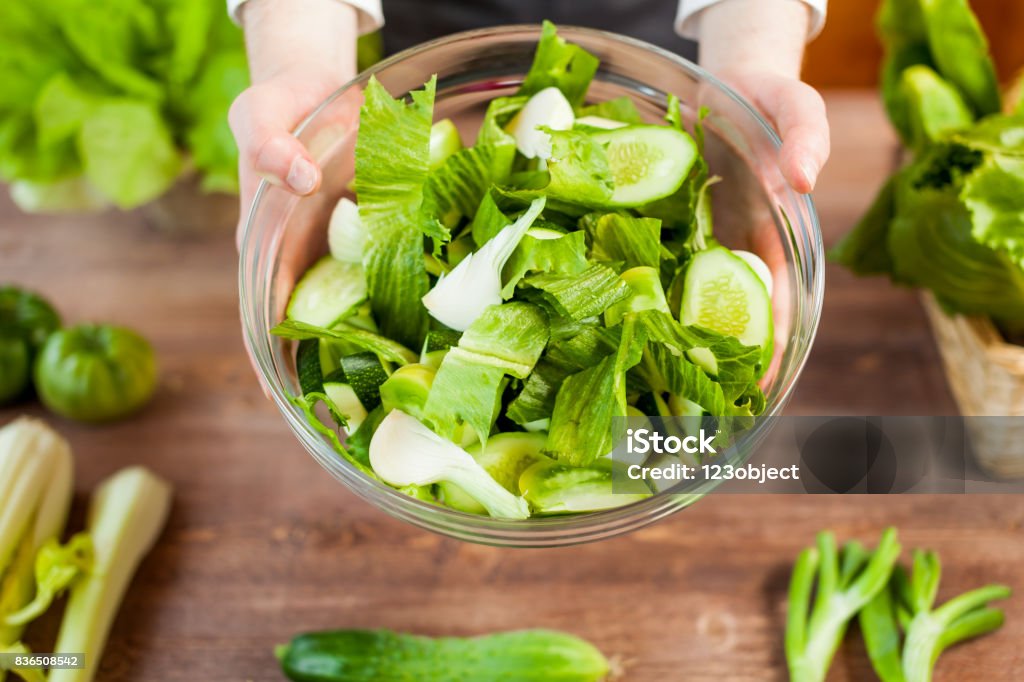 mãos segurando uma salada saudável vegetariana fresco verde em uma tigela - Foto de stock de Adulto royalty-free