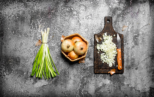 Fresh chopped onion on the old Board. On rustic background.