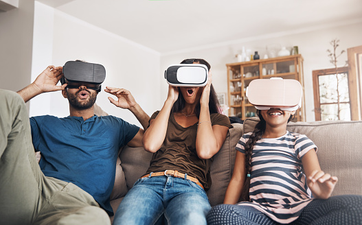 Shot of a young family using virtual reality headsets together at home