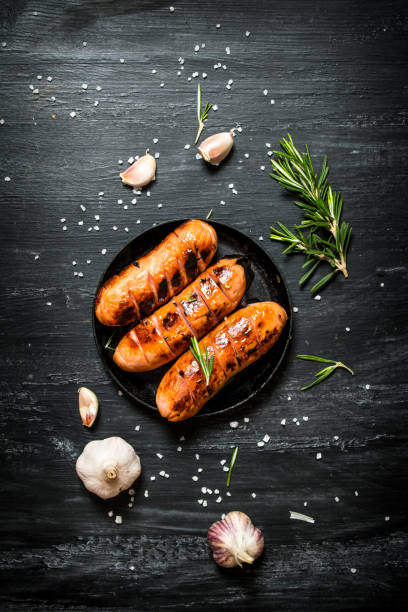 istock Fried sausages with garlic and herbs in a pan. 836526914