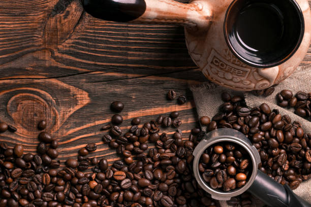 istock Old coffee cup and turk with roasted beans on a wooden table 836531044