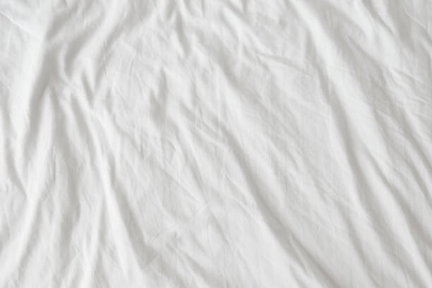 Top view of wrinkles, bed linen not cleaned after a restful sleep. Top view of wrinkles, bed linen not cleaned after a restful sleep. bed sheets stock pictures, royalty-free photos & images