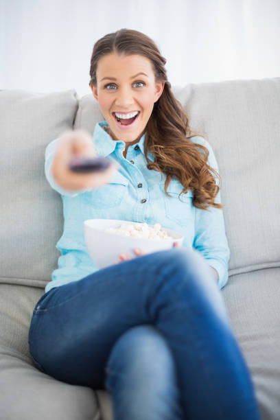 istock Smiling woman changing tv channel 836535694