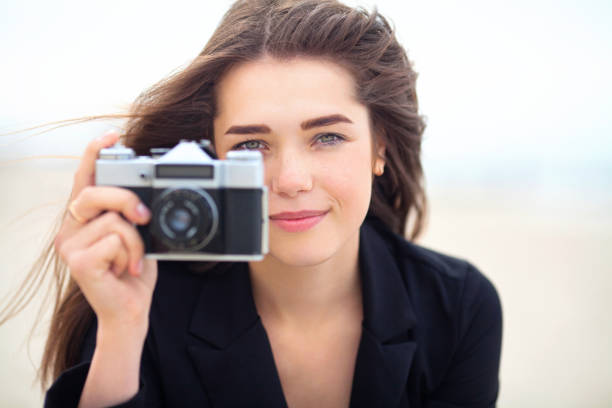 Beautiful young girl holding old film camera stock photo